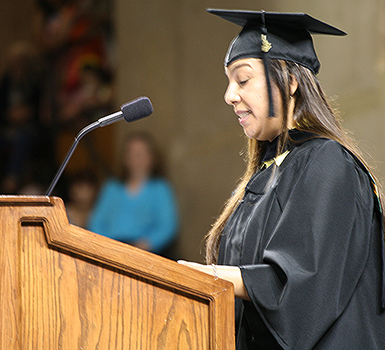 MC Student speaking at podium at commencement