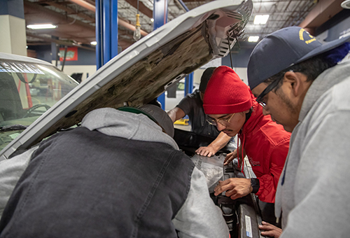 Automotive Technology students examining an engine