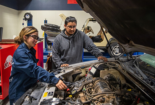 Automotive Technology students examining an engine