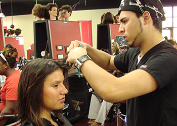 Cosmetology student styling hair at the MC salon