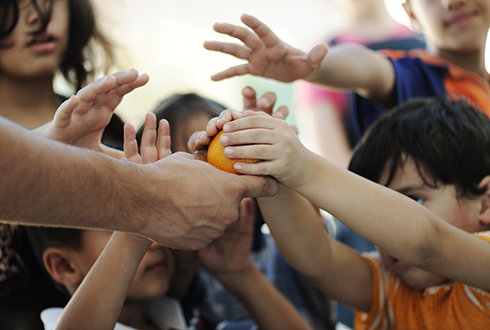 Responder reaching out to hungry children in the streets