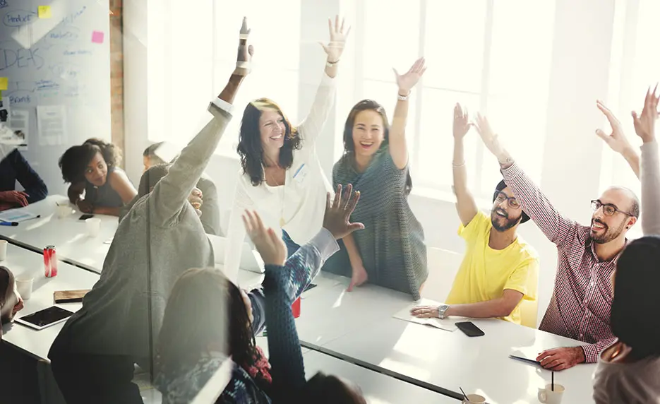 Classroom of adult students raising their hand