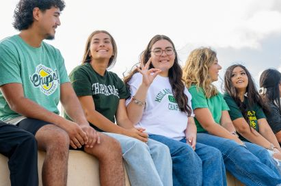 students on bench smiling at camera