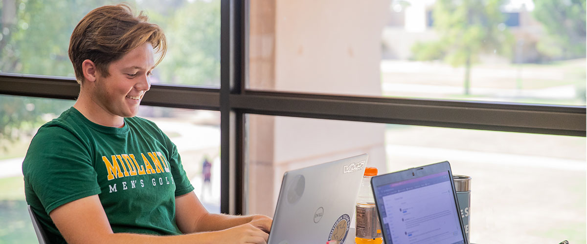 MC Student studying with laptop in library