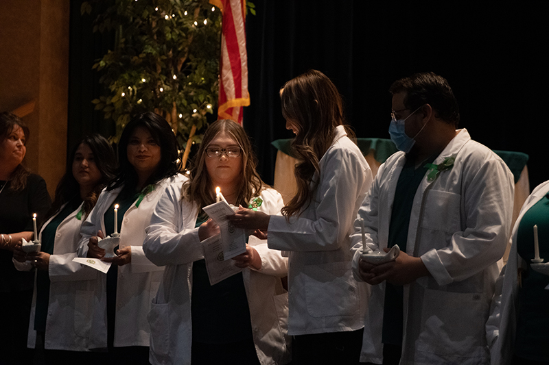The image to use for this article. Listing image managed through RSS tab. Associate Degree Nursing students lighting candles during pinning ceremony.