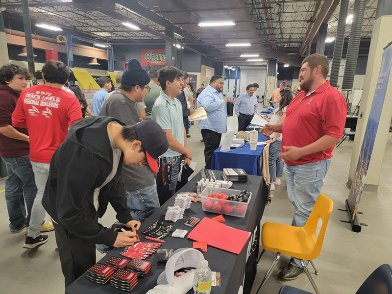 sMidland College students visit with Orlando Aguero of Double T Oilfield Services to discuss possible job opportunities during Industry Career/Intern Fair held at the Midland College Advanced Technology Center on April 20.