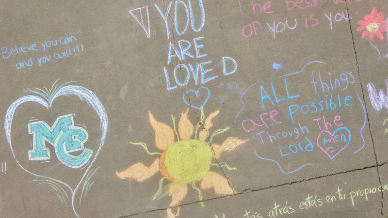 ssidewalks covered in messages of hope and support written in chalk