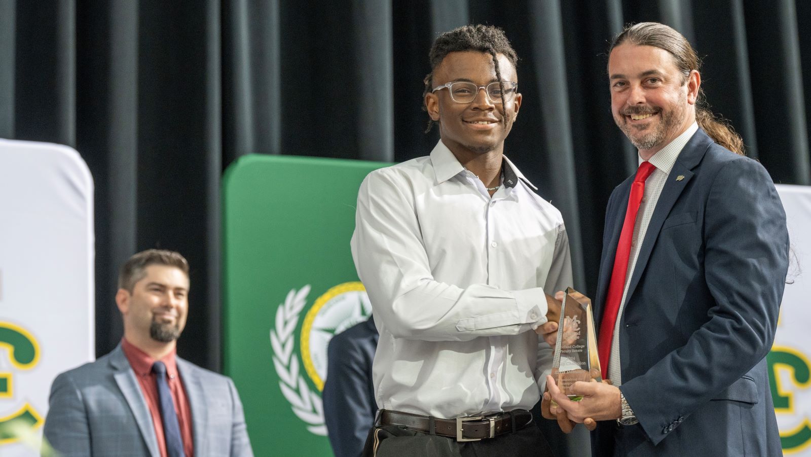 sElvis Dominic receives the Chap Champion award from Dr. Damon Kennedy