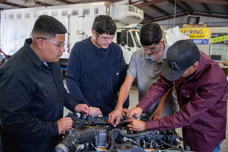 The image to use for this article. Listing image managed through RSS tab. Four Diesel Technology students working on diesel engine.