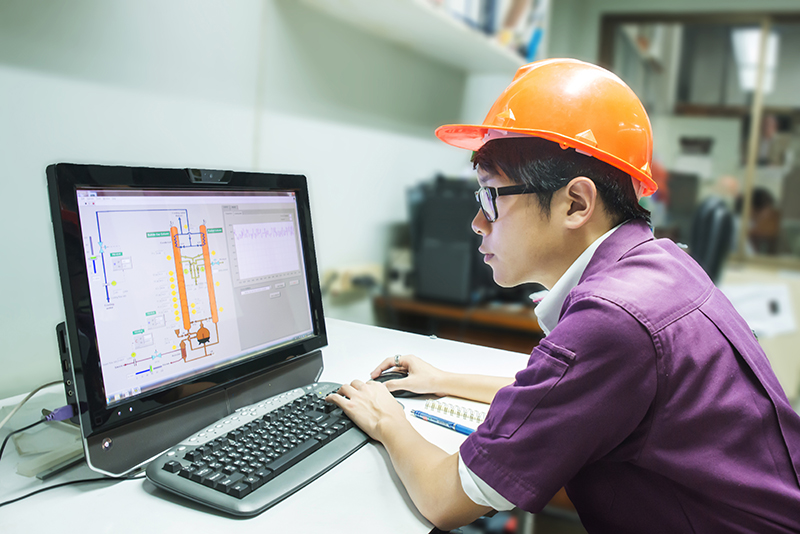 The image to use for this article. Listing image managed through RSS tab. Asian man sitting at computer wearing hard hat