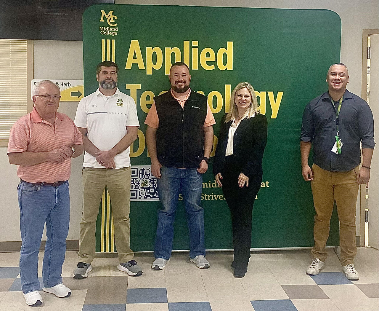 sezops employees and erick gutierrez pose in front of applied tech backdrop