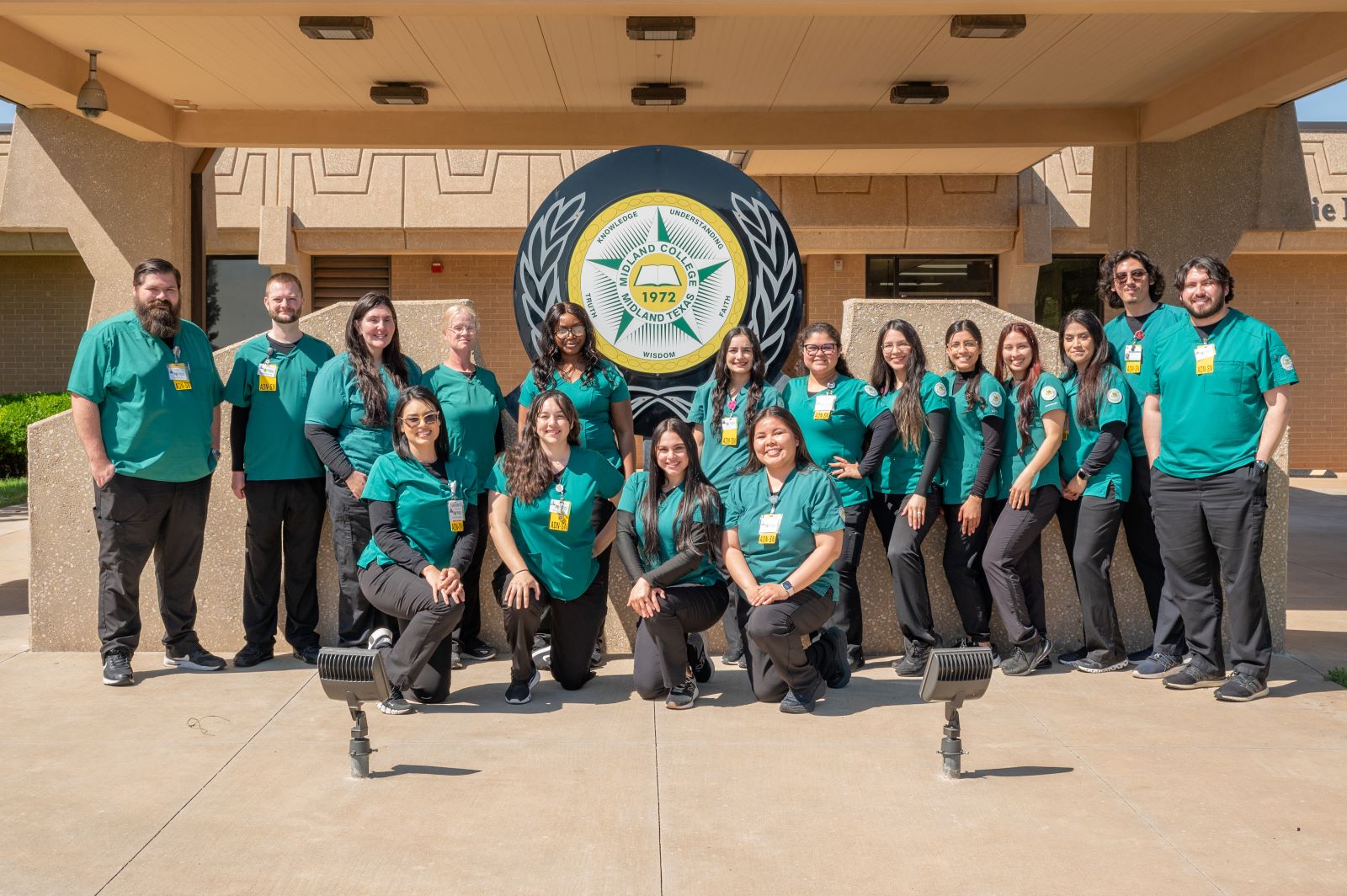 s17 associate degree nursing graduates pose in front of Midland College seal