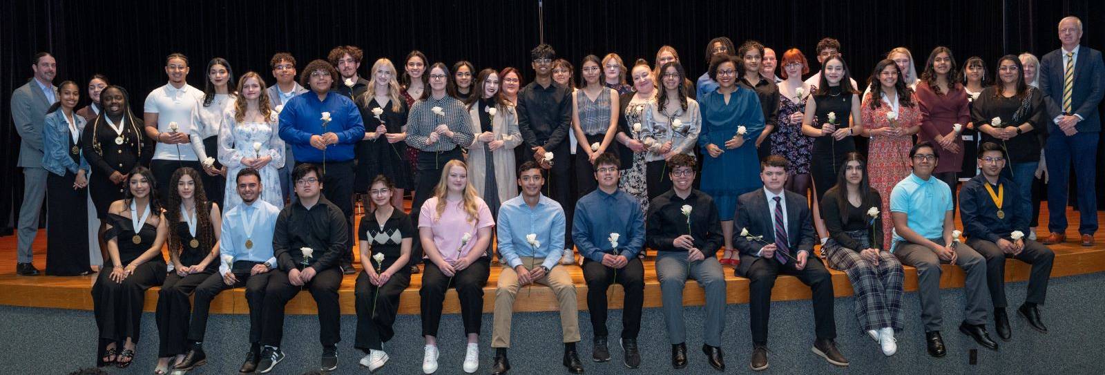 sPhi Theta Kappa inductees pose on stage at the Allison Fine Arts Building, Wagner & Brown Auditorium