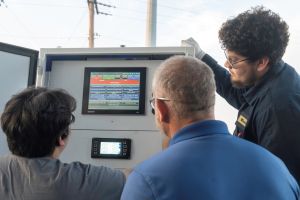sautomation students look at an automation tool with a professor