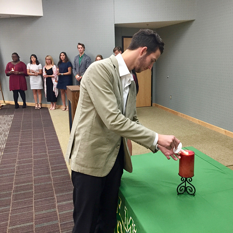 The image to use for this article. Listing image managed through RSS tab. 2019-2020 MC Students in Philanthropy Vice President Lawson Bell lights candle during commissioning ceremony.