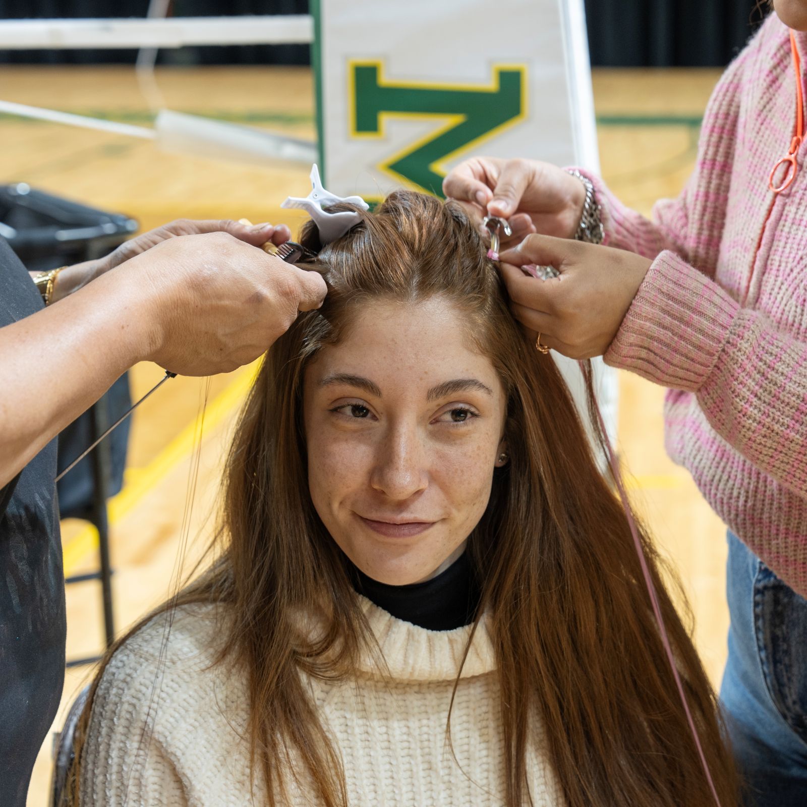smc volleyball player Iasmin Aruajo gets a pink hair extension placed in her hair