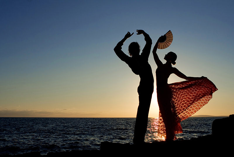 sFlamenco dancers on beach at sunset